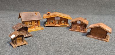 cinq petites maisons en bois posées par terre