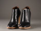 a pair of black leather ankle boots with a wooden heel