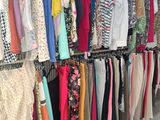a lot of clothes hanging on a rack in a room