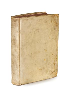 un vieux livre posé sur une table blanche à côté d'un mur blanc