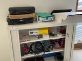 a white bookcase with a bunch of electronics on top of it