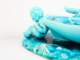 une figurine représentant un garçon dans un bateau sur l'eau