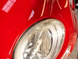 a close up of a car ' s headlight on a red car