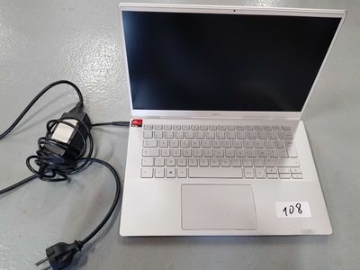 a white laptop computer sitting on a table with a charger