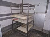 une étagère métallique avec des tablettes, placée dans un coin de la pièce