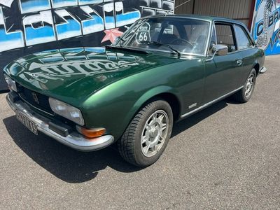 une voiture verte garée devant un immeuble