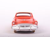 a red toy car that is sitting on a white surface