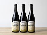trois bouteilles de vin posées sur une table en bois