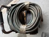 a hose that is attached to a cart on the sidewalk