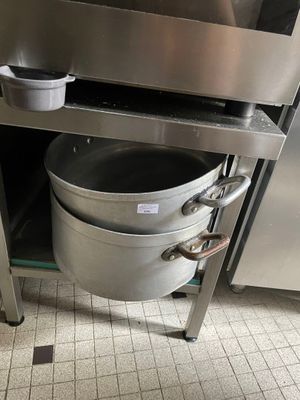 une grande casserole en métal posée au milieu d'une cuisine