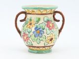a vase that has a handle on it with flowers on it
