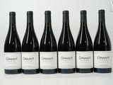 six bouteilles de vin sont alignées sur une table