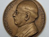 an image of a bronze medal with a man ' s face on it