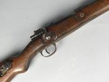 an old rifle with a wooden handle on a white surface