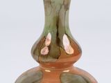 a glass vase with a flower on it sitting on a table