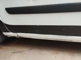 a white car with black stripes parked in a driveway