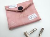une petite pochette rose avec une paire de ciseaux à côté