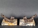 une paire de figurines en bronze représentant un garçon et une fille, posées sur des socles en marbre