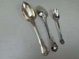 three spoons and two spoons sitting on a table
