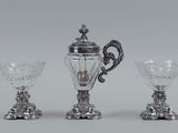 three pieces of silver and glass on a white surface