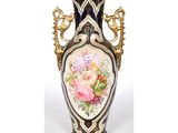a vase with flowers painted on it sitting on a table