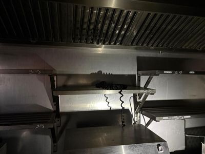 une cuisine équipée de plans de travail et d'étagères en acier inoxydable