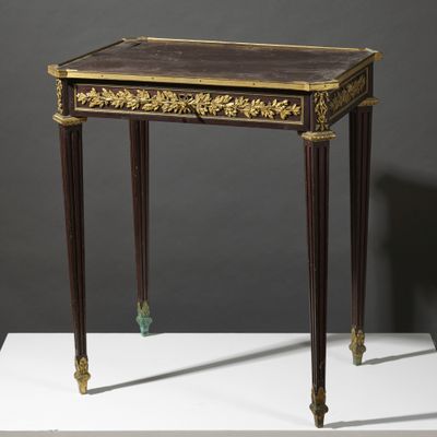 une petite table dont le plateau est orné d'un décor à la feuille d'or