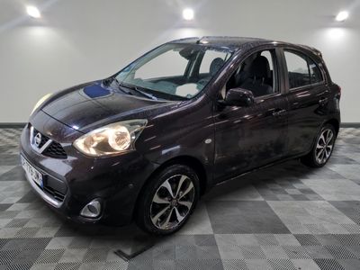 the small car is parked on a checkered floor in the garage
