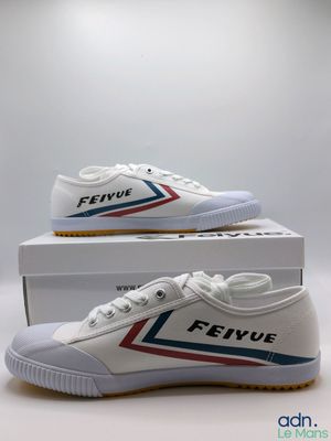 une paire de chaussures blanches ornées de rayures rouges, bleues et blanches