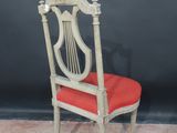 a wooden chair with a red seat and a black background