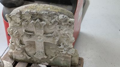 une statue représentant une croix posée sur une palette dans un garage
