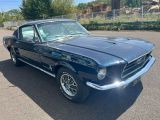 une photo d'une Mustang noire garée sur un parking