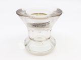 un petit vase en verre contenant une bougie