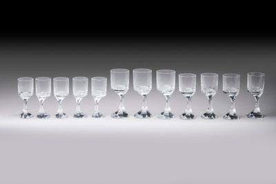 plusieurs verres à vin vides sont alignés sur une surface blanche