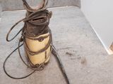 une vieille boîte en fer posée par terre à côté d'un marteau
