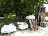 a pile of pallets sitting on the ground next to a tree
