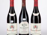 trois bouteilles de vin rouge posées l'une à côté de l'autre sur une surface blanche