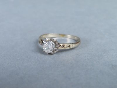 gros plan d'une bague en diamant sur une surface grise