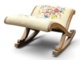 a small rocking chair with a floral design on it