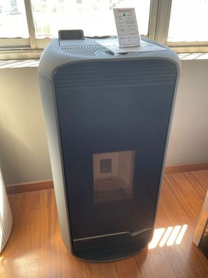 un petit purificateur d'air posé sur un parquet près d'une fenêtre