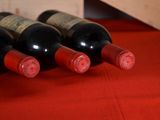 several bottles of wine are lined up on a red table cloth