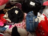 a pile of clothes that is sitting on a bed