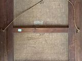 an old wooden frame with a rope hanging from it ' s side