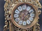 a gold clock with roman numerals on the face
