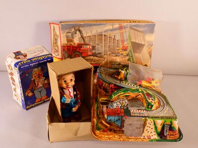 une boîte contenant une poupée, à côté d'une boîte contenant un circuit de train