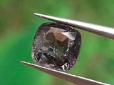 un gros plan d'un diamant noir tenu par une pince