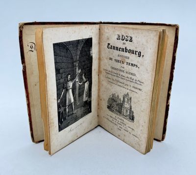 un livre ouvert sur lequel figure l'image d'un homme et d'une femme debout devant un immeuble