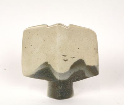 a picture of a ceramic object with a bird flying over it