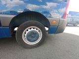 a blue van parked in a parking lot next to a blue van