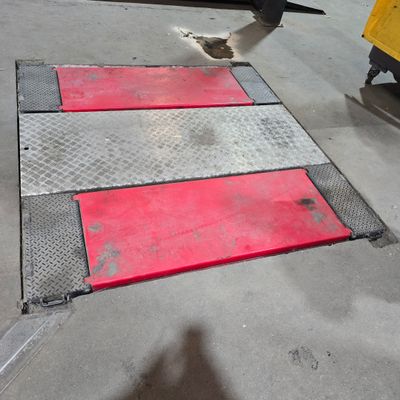 a red and white stripe on the ground next to a yellow truck